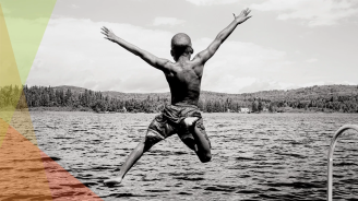 A black and white photo of a person jumping into a lake